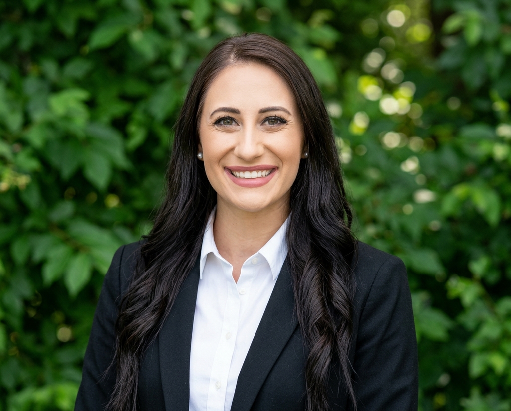 Real estate agent headshot against a leafy green outdoor backdrop